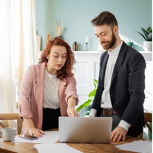 Two colleagues reviewing a project on a laptop