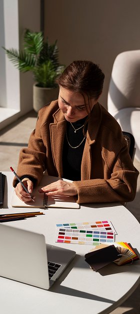 Designer working with colour swatches and a notebook